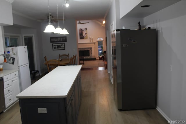 300 Crestway Ct, Saline, MI 48176 - kitchen featuring freestanding refrigerator, light countertops, a fireplace, a kitchen island, and crown molding