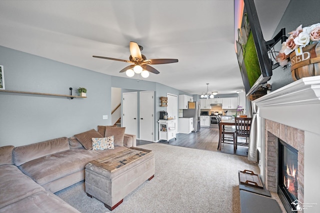 773 Hunting Creek Rd, Temperance, MI 48182 - living area featuring dark colored carpet, ceiling fan, a glass covered fireplace, a chandelier, and stairway