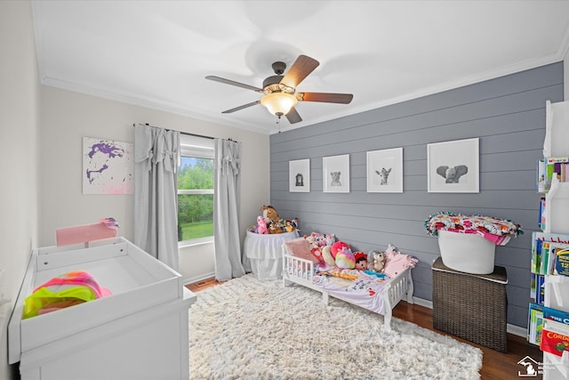 773 Hunting Creek Rd, Temperance, MI 48182 - bedroom featuring crown molding, wood finished floors, a crib, a ceiling fan, and wood walls