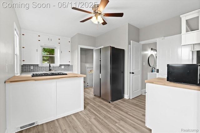 4469 5th St, Ecorse, MI 48229 - kitchen featuring butcher block countertops, freestanding refrigerator, a ceiling fan, white cabinetry, and light wood finished floors