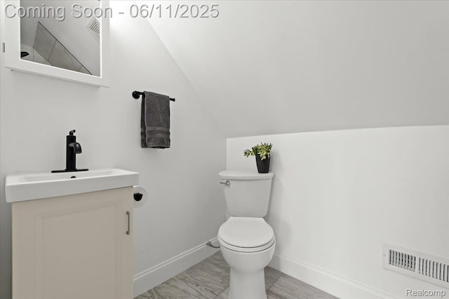 4469 5th St, Ecorse, MI 48229 - bathroom with vanity, toilet, baseboards, and lofted ceiling