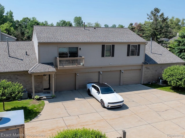 140 Pine Tree Ridge Dr Unit 2, Waterford, MI 48327 - view of front of property featuring concrete driveway, a garage, roof with shingles, brick siding, and a balcony