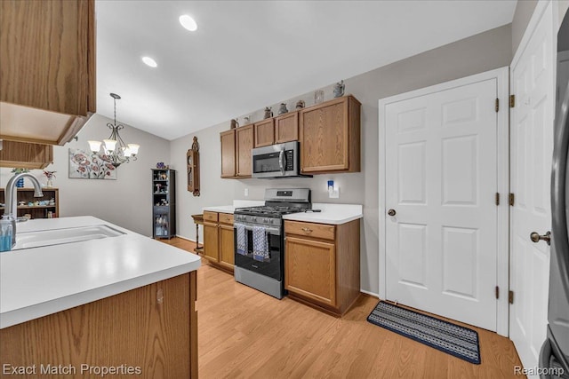 140 Pine Tree Ridge Dr Unit 2, Waterford, MI 48327 - kitchen featuring appliances with stainless steel finishes, a sink, brown cabinets, light wood-type flooring, and vaulted ceiling