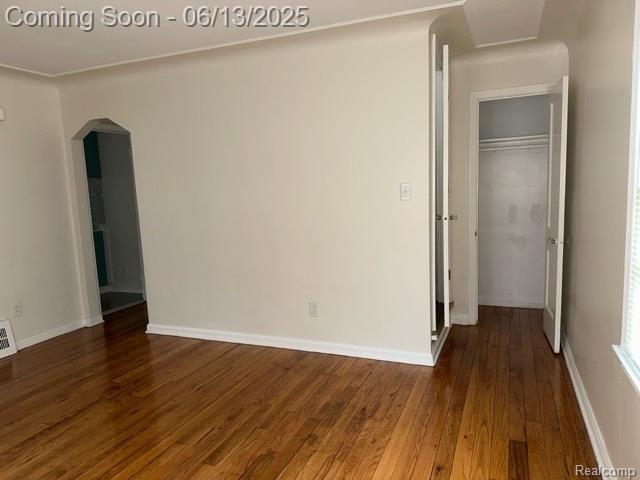 19628 Elkhart St, Harper Woods, MI 48225 - unfurnished room featuring wood-type flooring, arched walkways, and baseboards