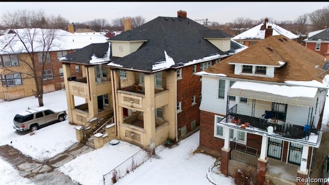 2340 Clements St, Detroit, MI 48238 - snow covered rear of property with a chimney and brick siding