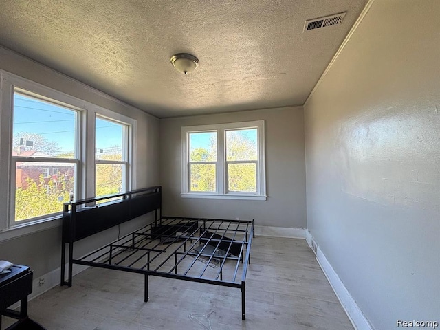 2340 Clements St, Detroit, MI 48238 - bedroom featuring a textured ceiling, baseboards, and wood finished floors