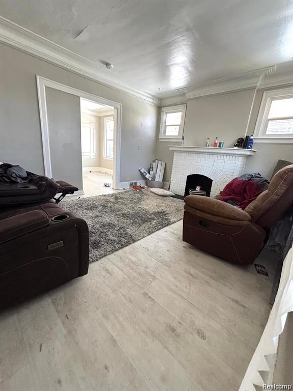 2340 Clements St, Detroit, MI 48238 - living area with ornamental molding, wood finished floors, and a brick fireplace