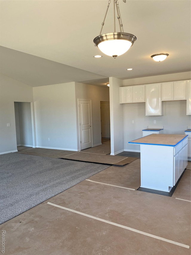 33548 Baldwin St, Farmington Hills, MI 48336 - kitchen featuring white cabinets, finished concrete floors, a kitchen island, and hanging light fixtures