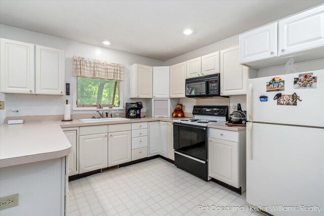 376 Stauffer Dr, Hastings, MI 49058 - kitchen with freestanding refrigerator, electric stove, black microwave, a sink, and white cabinets