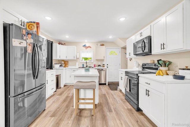5668 Mill St, Peck, MI 48466 - kitchen featuring appliances with stainless steel finishes, white cabinetry, a kitchen island, light wood-style floors, and a sink