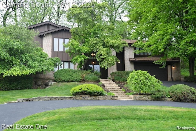 3058 Bloomfield Park Dr, West Bloomfield, MI 48323 - view of front facade featuring brick siding, asphalt driveway, a garage, a front lawn, and board and batten siding