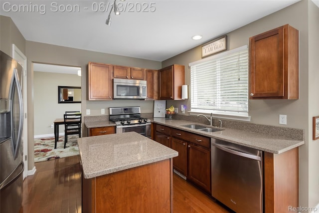 18885 English Ivy Dr, Macomb, MI 48042 - kitchen with appliances with stainless steel finishes, a sink, a center island, dark wood-style flooring, and light stone countertops