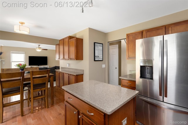 18885 English Ivy Dr, Macomb, MI 48042 - kitchen featuring stainless steel fridge, brown cabinetry, light wood finished floors, a ceiling fan, and a center island