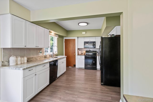 819 N Ball St, Owosso, MI 48867 - kitchen with black appliances, a sink, and white cabinetry