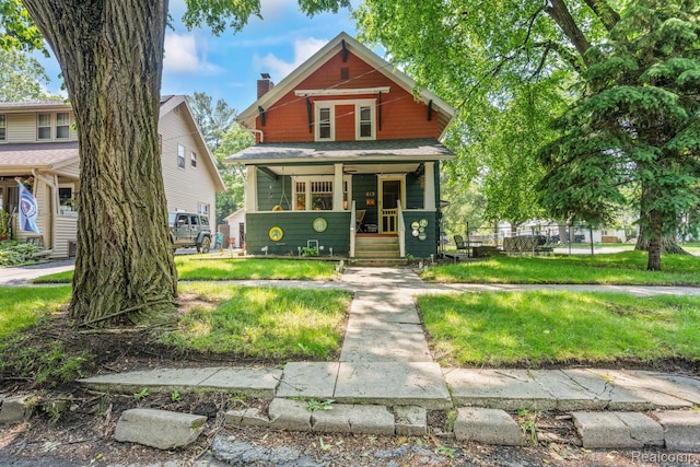 819 N Ball St, Owosso, MI 48867 - view of front facade with covered porch and a chimney