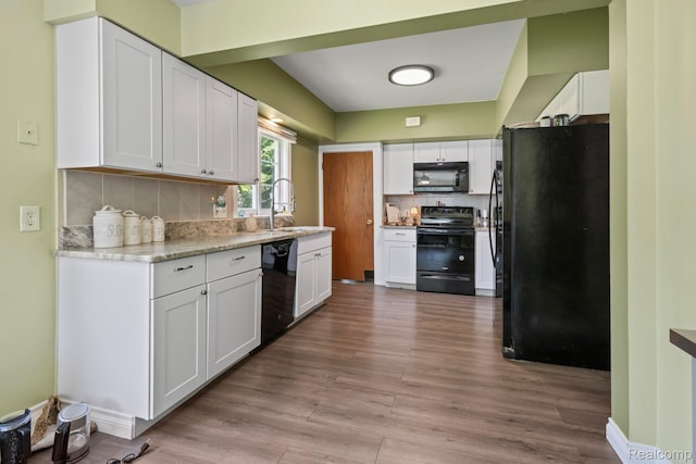 819 N Ball St, Owosso, MI 48867 - kitchen with black appliances, white cabinets, tasteful backsplash, and a sink