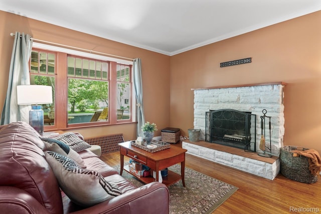819 N Ball St, Owosso, MI 48867 - living room featuring crown molding, wood finished floors, and a stone fireplace