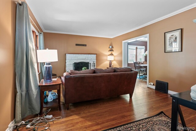 819 N Ball St, Owosso, MI 48867 - living room with hardwood / wood-style flooring, a stone fireplace, ornamental molding, and baseboards
