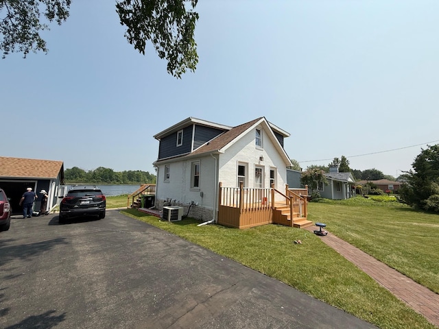303 S Lemen St, Fenton, MI 48430 - view of front facade with cooling unit, a deck with water view, a front lawn, and brick siding