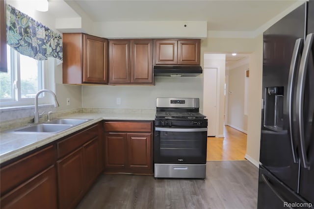 3581 Stolzenfeld Ave, Warren, MI 48091 - kitchen with stainless steel appliances, under cabinet range hood, a sink, light countertops, and dark wood-style floors