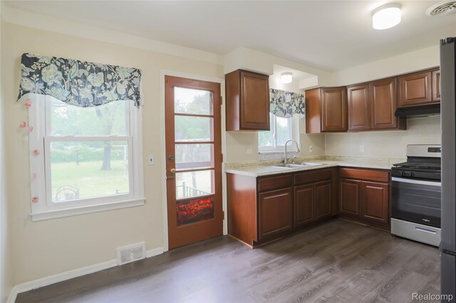 3581 Stolzenfeld Ave, Warren, MI 48091 - kitchen with stainless steel gas range oven, a sink, under cabinet range hood, light countertops, and dark wood-style floors