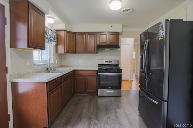 3581 Stolzenfeld Ave, Warren, MI 48091 - kitchen with refrigerator with ice dispenser, stainless steel gas stove, a sink, under cabinet range hood, and dark wood-style floors