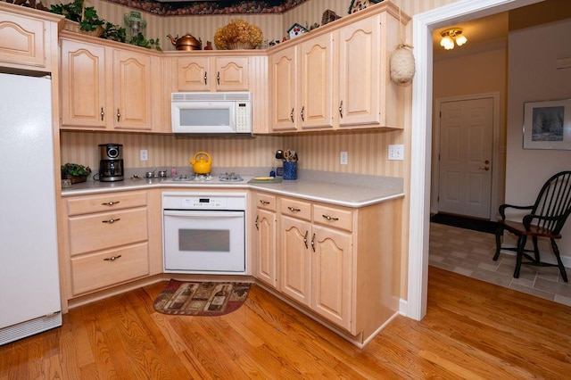 1480 Nelson Rd, Saint Joseph, MI 49085 - kitchen with white appliances, light countertops, light brown cabinets, and light wood-style floors