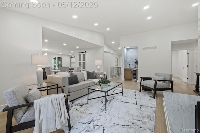 3405 Pine Estates Dr, Bloomfield Hills, MI 48323 - living room with beverage cooler, light wood-style floors, a barn door, recessed lighting, and lofted ceiling