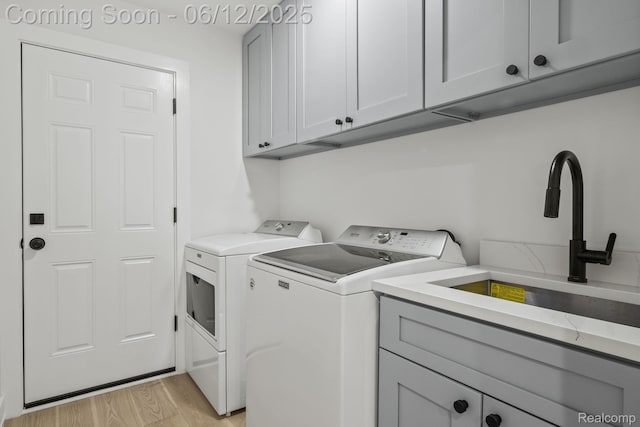 3405 Pine Estates Dr, Bloomfield Hills, MI 48323 - laundry area featuring washing machine and clothes dryer, cabinet space, and light wood-style flooring
