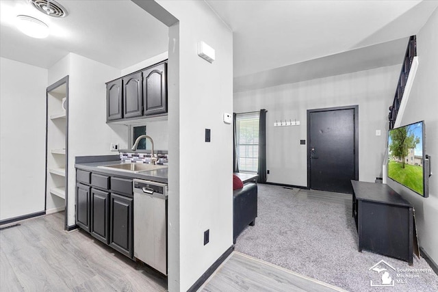 20036 Village Green Ct, Brownstown, MI 48183 - kitchen with dishwasher, a sink, light wood-style floors, and baseboards