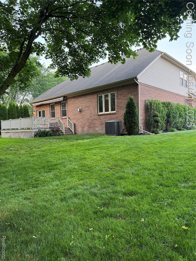 34444 Fargo St, Livonia, MI 48152 - back of house featuring brick siding, a wooden deck, and a lawn