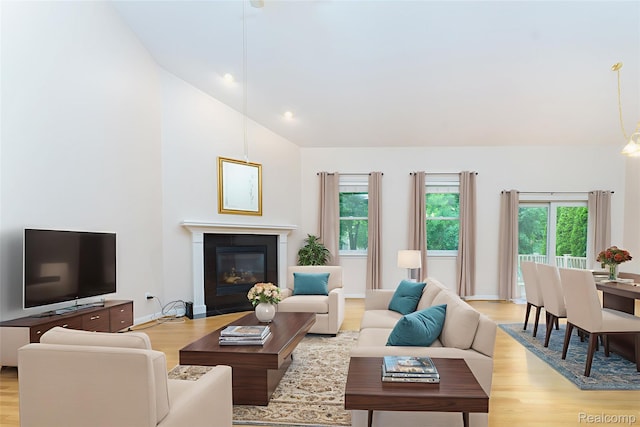 34444 Fargo St, Livonia, MI 48152 - living room featuring light wood-style floors, lofted ceiling, and a fireplace with flush hearth