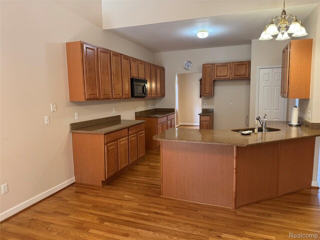 34444 Fargo St, Livonia, MI 48152 - kitchen with black microwave, a peninsula, and light wood-style flooring