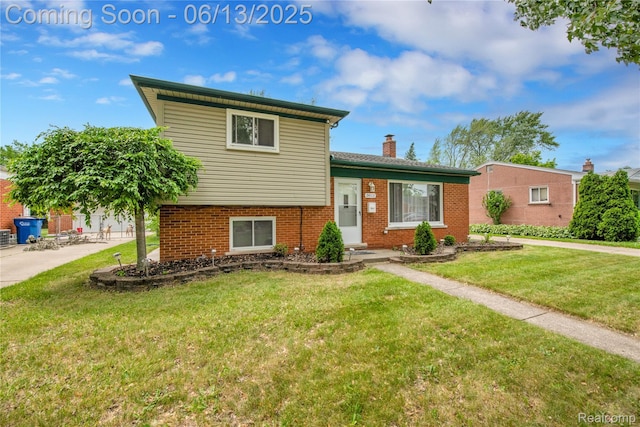 24113 Karen Ave, Warren, MI 48091 - split level home featuring a chimney, a front yard, and brick siding