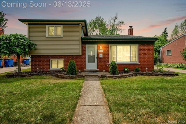 24113 Karen Ave, Warren, MI 48091 - tri-level home featuring a front yard, a chimney, and brick siding