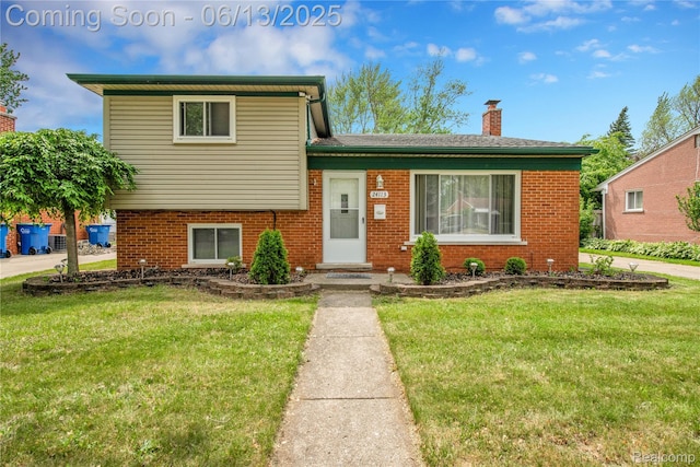 24113 Karen Ave, Warren, MI 48091 - tri-level home with brick siding, a front yard, and a chimney