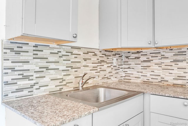 20069 Goulburn St, Detroit, MI 48205 - kitchen featuring a sink, tasteful backsplash, and white cabinets