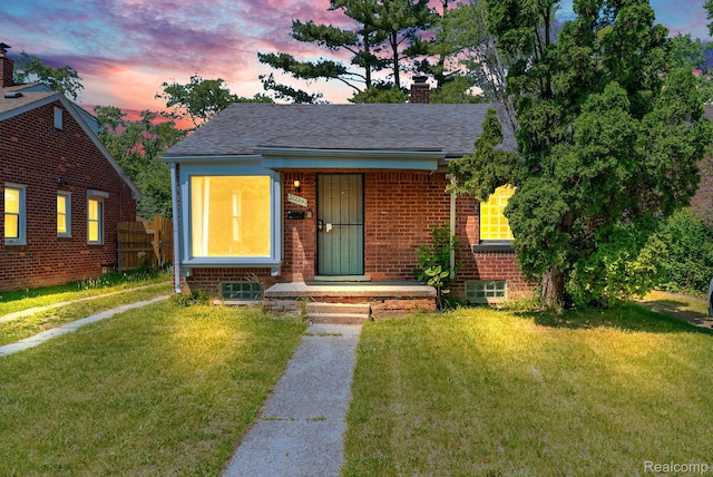 20069 Goulburn St, Detroit, MI 48205 - bungalow-style house featuring brick siding, a lawn, a chimney, and a shingled roof