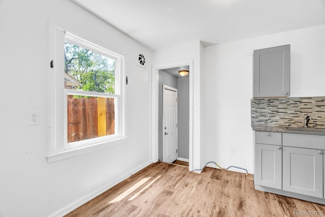 20069 Goulburn St, Detroit, MI 48205 - unfurnished dining area with a sink, light wood-style floors, and baseboards