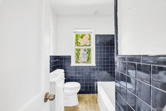 20069 Goulburn St, Detroit, MI 48205 - bathroom with tile walls, vanity, a tub, toilet, and wood finished floors