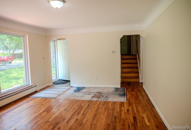 46254 Custer Ave, Utica, MI 48317 - unfurnished room with arched walkways, wood finished floors, healthy amount of natural light, and stairway