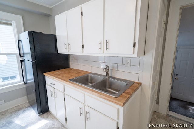 884 Emerson Ave, Muskegon, MI 49442 - kitchen featuring a sink, tasteful backsplash, light countertops, and white cabinets