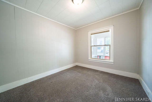 884 Emerson Ave, Muskegon, MI 49442 - spare room with crown molding, dark colored carpet, and baseboards