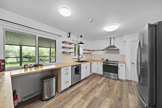 2618 Greencliff Dr, East Lansing, MI 48823 - kitchen with appliances with stainless steel finishes, butcher block counters, wall chimney range hood, open shelves, and a sink