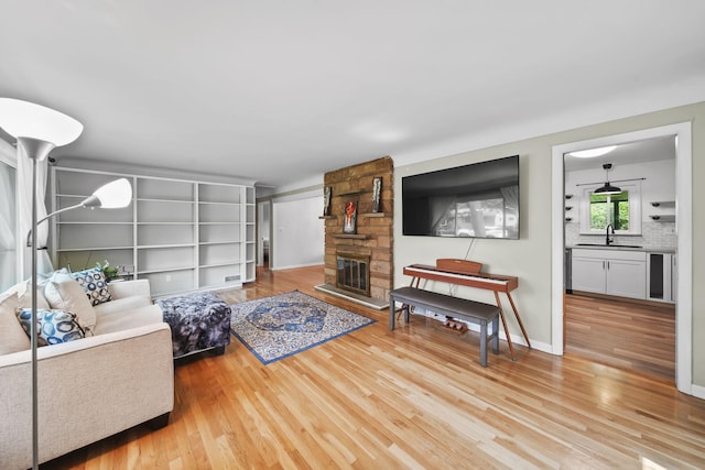 2618 Greencliff Dr, East Lansing, MI 48823 - living area with wood finished floors, a stone fireplace, and baseboards