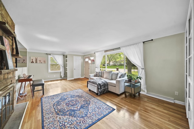 2618 Greencliff Dr, East Lansing, MI 48823 - living area with baseboard heating, plenty of natural light, a fireplace, and wood finished floors