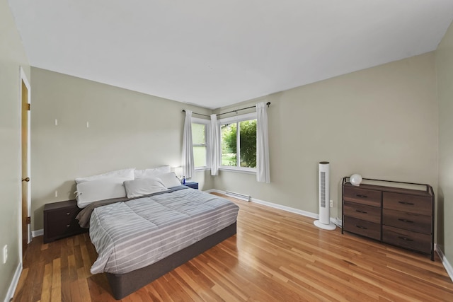 2618 Greencliff Dr, East Lansing, MI 48823 - bedroom with wood finished floors, baseboards, and a baseboard radiator