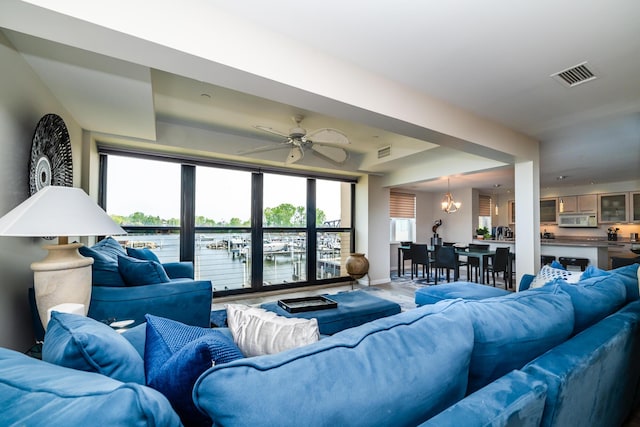240 Water St Unit 1A, Saint Joseph, MI 49085 - living area featuring a chandelier, a water view, ceiling fan, wood finished floors, and baseboards