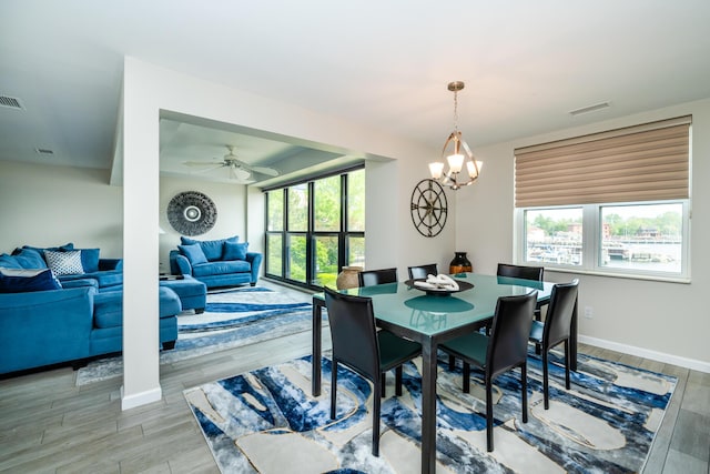 240 Water St Unit 1A, Saint Joseph, MI 49085 - dining space with wood finished floors, baseboards, a ceiling fan, and a chandelier