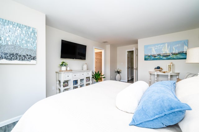 240 Water St Unit 1A, Saint Joseph, MI 49085 - bedroom featuring baseboards, wood finished floors, and a spacious closet